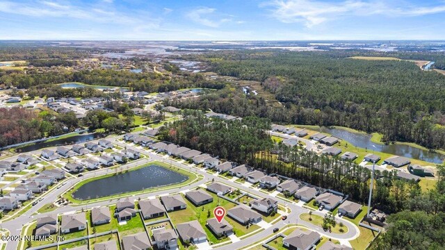 birds eye view of property featuring a wooded view, a water view, and a residential view