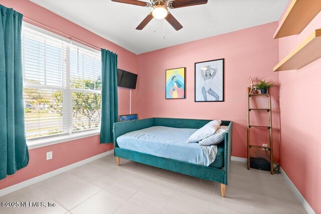 tiled bedroom with a ceiling fan and baseboards