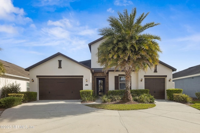 view of front of home featuring concrete driveway, an attached garage, and stucco siding