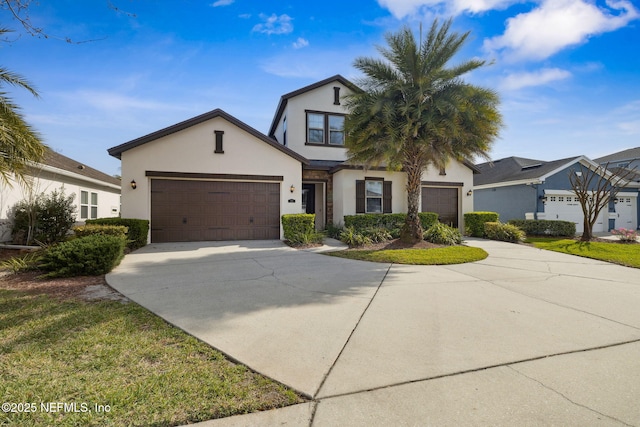 view of front of home featuring concrete driveway, an attached garage, and stucco siding