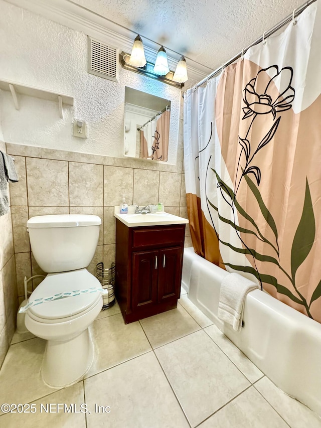 full bathroom featuring tile walls, shower / bath combination with curtain, tile patterned flooring, and a textured ceiling