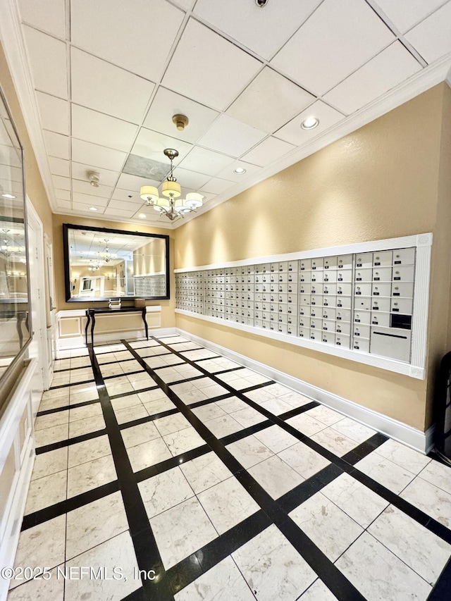 unfurnished room with mail boxes, a paneled ceiling, and ornamental molding