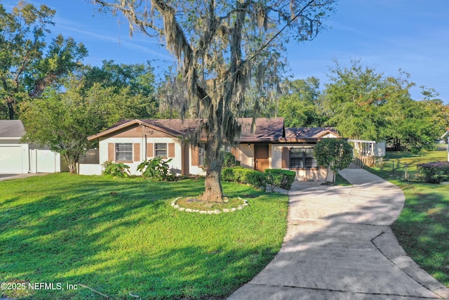 view of front of property featuring driveway, brick siding, a front yard, and fence