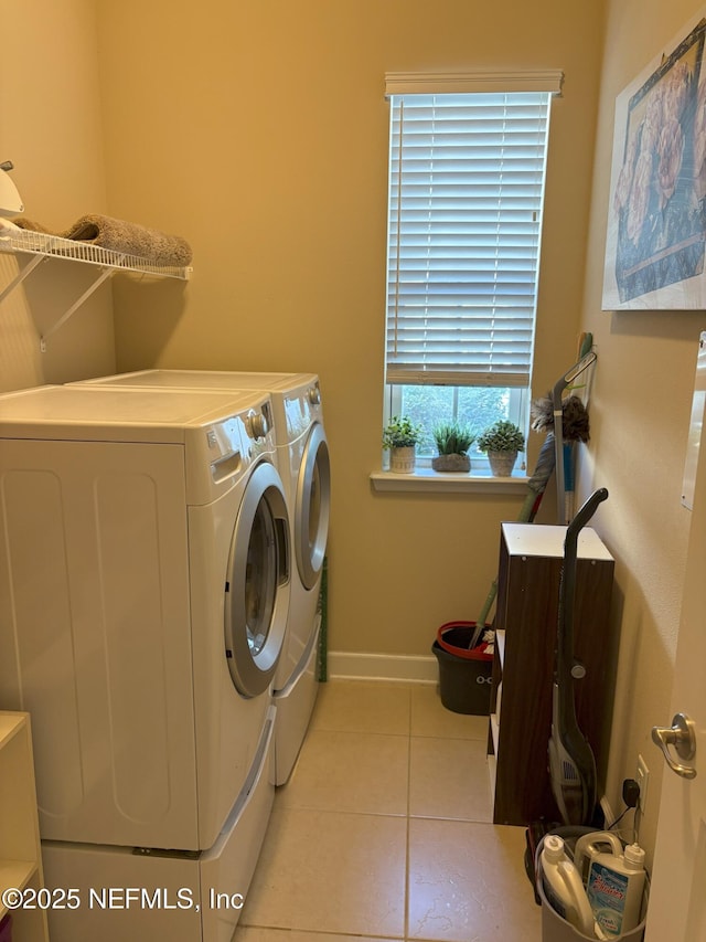 clothes washing area featuring light tile patterned flooring and washer and dryer