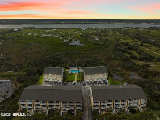 aerial view at dusk featuring a water view