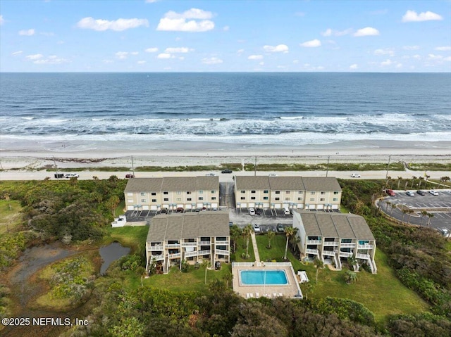 drone / aerial view with a water view and a beach view