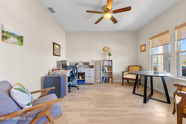 office space with light wood-type flooring, visible vents, ceiling fan, and baseboards