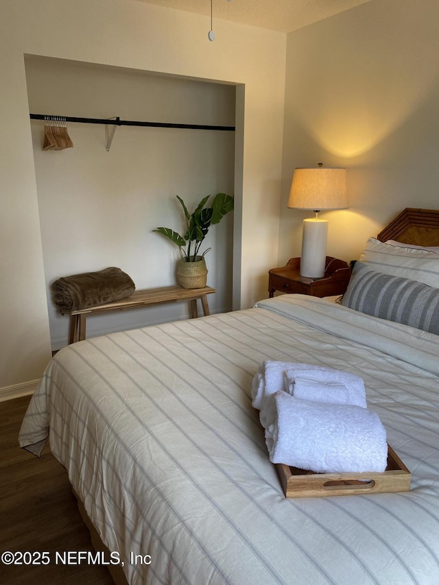 bedroom with baseboards and wood finished floors