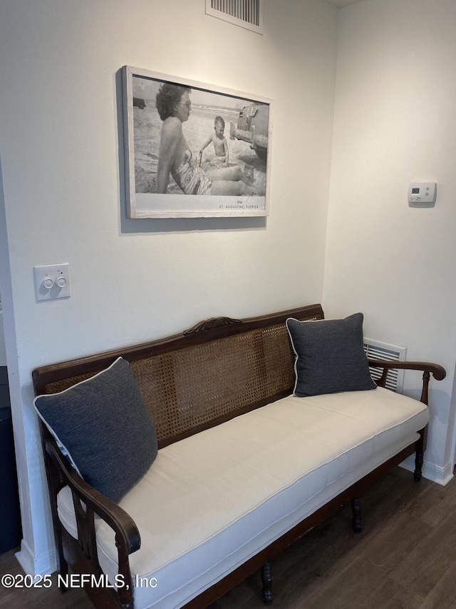 sitting room featuring wood finished floors, visible vents, and baseboards