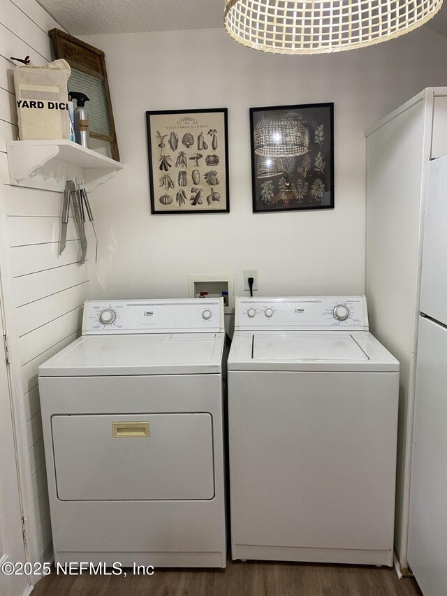 laundry area featuring laundry area, washing machine and clothes dryer, and wood finished floors