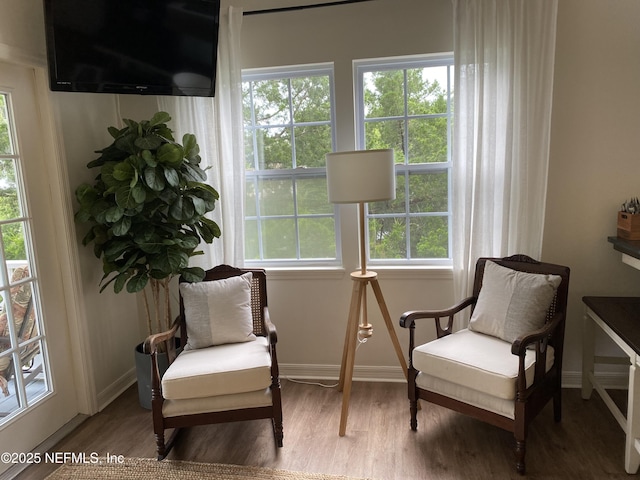 living area with baseboards and wood finished floors