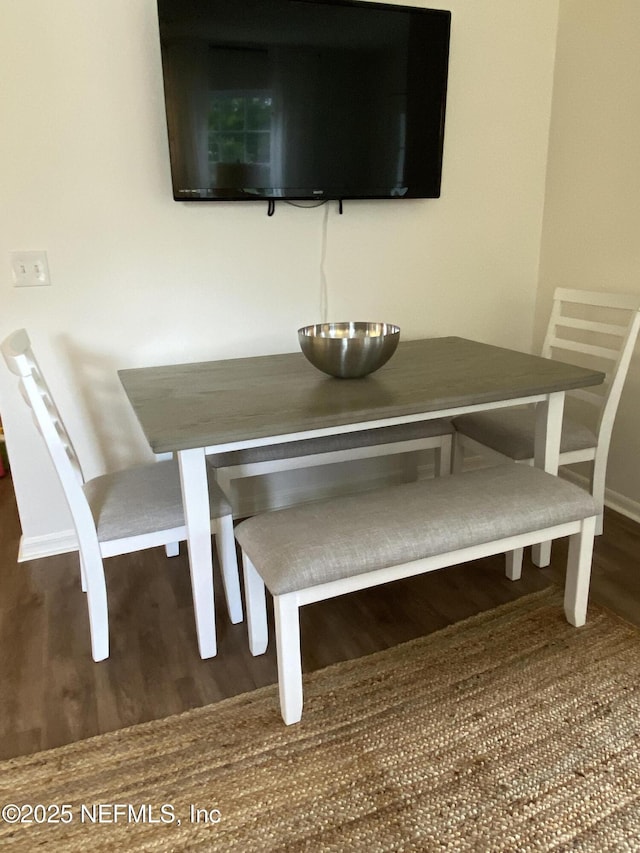 unfurnished dining area featuring baseboards and wood finished floors