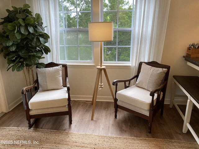 living area with baseboards and wood finished floors