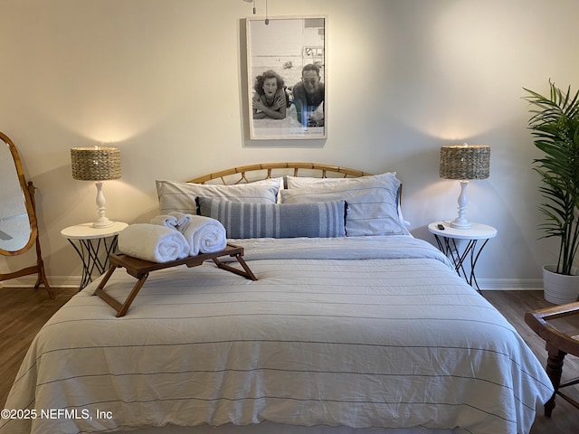 bedroom with baseboards and wood finished floors