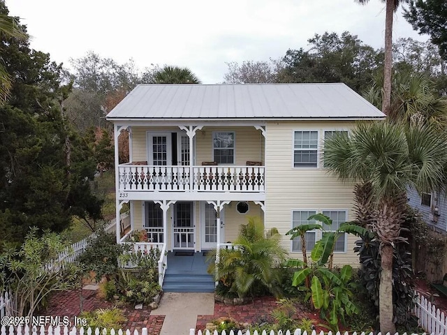 view of front of home featuring metal roof, a porch, and a balcony