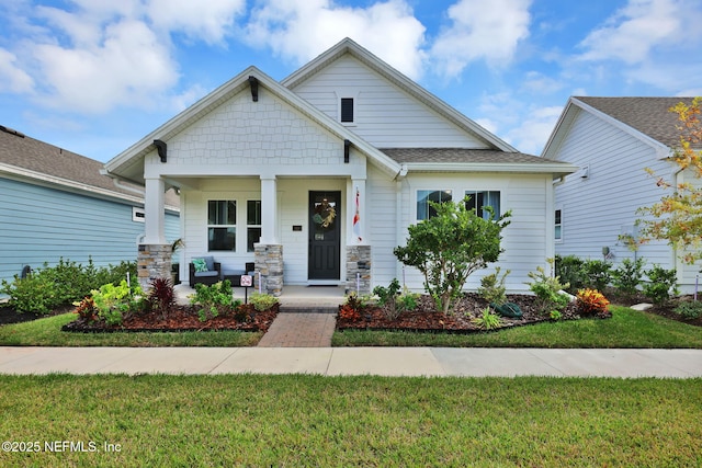 view of front of home with covered porch and a front lawn