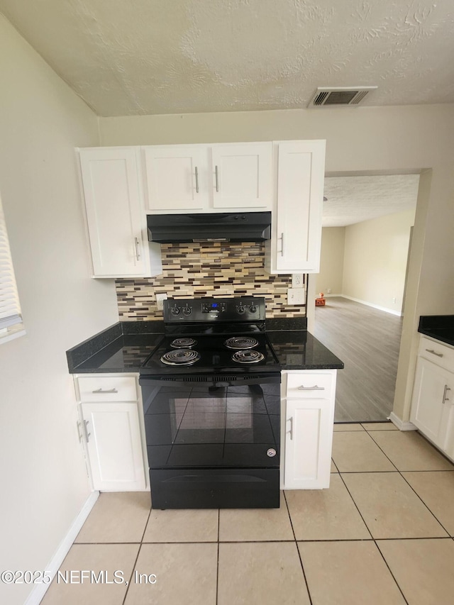 kitchen featuring light tile patterned floors, under cabinet range hood, white cabinetry, black electric range oven, and dark countertops