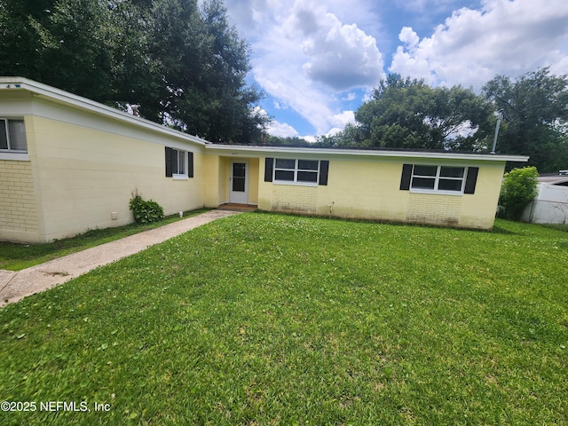 single story home featuring brick siding, a front yard, and fence