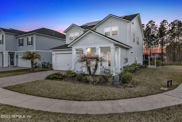 view of front of house featuring a garage, decorative driveway, and board and batten siding