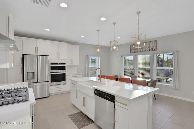 kitchen with visible vents, white cabinets, stainless steel appliances, light countertops, and a sink