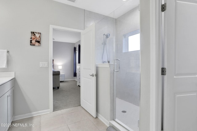 ensuite bathroom featuring tile patterned flooring, vanity, baseboards, a shower stall, and ensuite bath