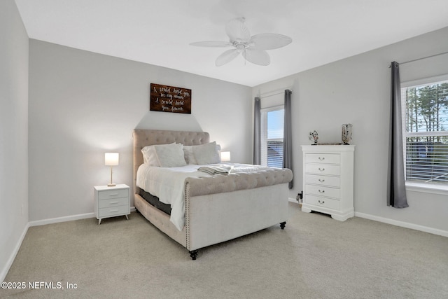 bedroom with a ceiling fan, light colored carpet, and baseboards