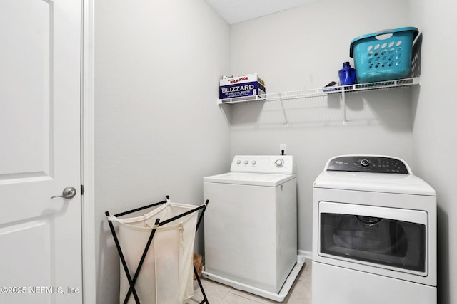 clothes washing area with laundry area, light tile patterned flooring, and washing machine and dryer