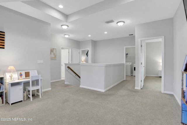 interior space featuring light colored carpet, visible vents, an upstairs landing, baseboards, and washer / dryer