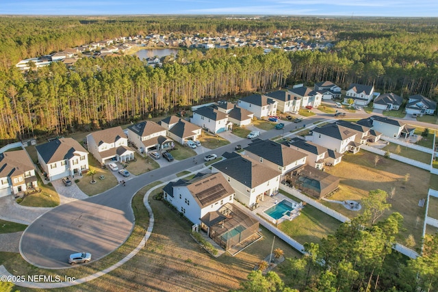 aerial view featuring a water view, a residential view, and a view of trees