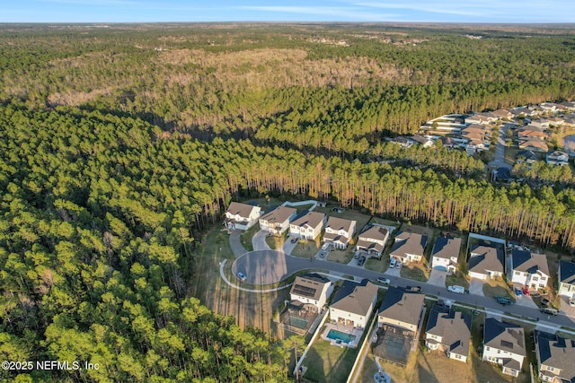 drone / aerial view with a wooded view and a residential view