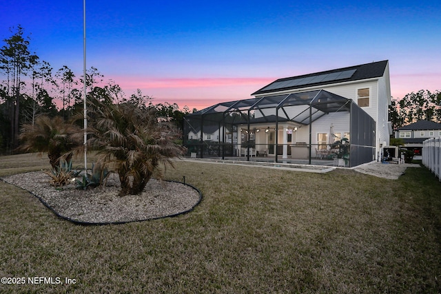 back of house with glass enclosure, a yard, and a patio