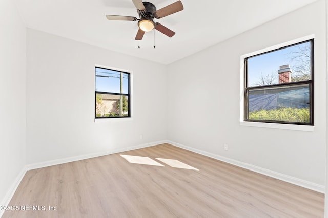 empty room with light wood-style floors, baseboards, and a ceiling fan