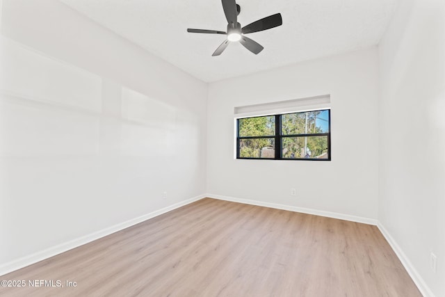 spare room with light wood-style floors, baseboards, and a ceiling fan