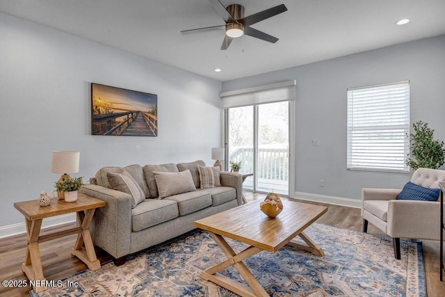 living room featuring ceiling fan and light hardwood / wood-style floors