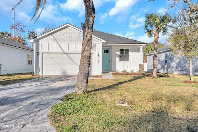 view of front of home with a front yard and a garage