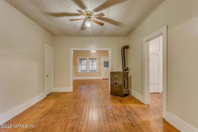 spare room featuring wood-type flooring, ornamental molding, ceiling fan, a textured ceiling, and baseboards