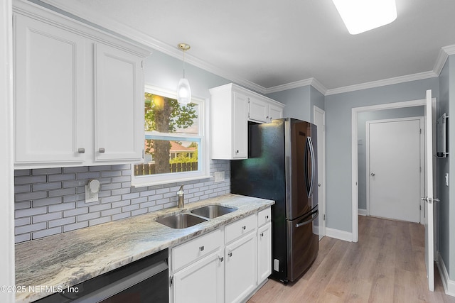 kitchen featuring a sink, white cabinetry, freestanding refrigerator, light stone countertops, and dishwasher