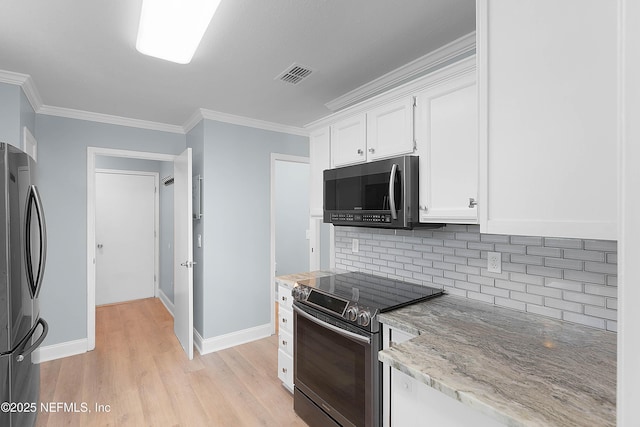 kitchen featuring visible vents, light wood-style flooring, ornamental molding, stainless steel appliances, and white cabinets