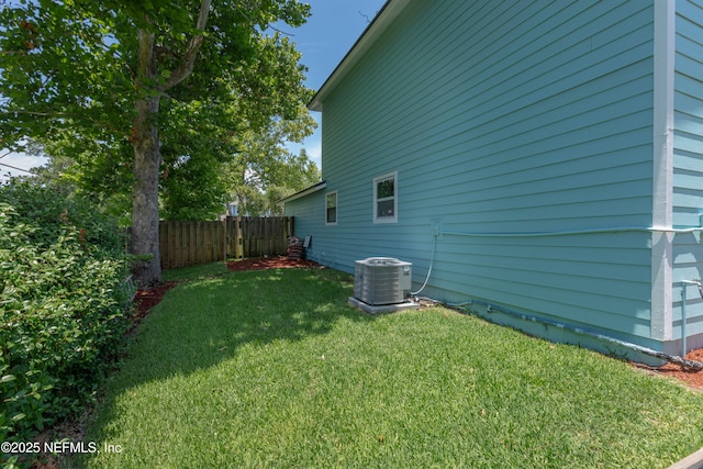 view of yard with cooling unit and fence