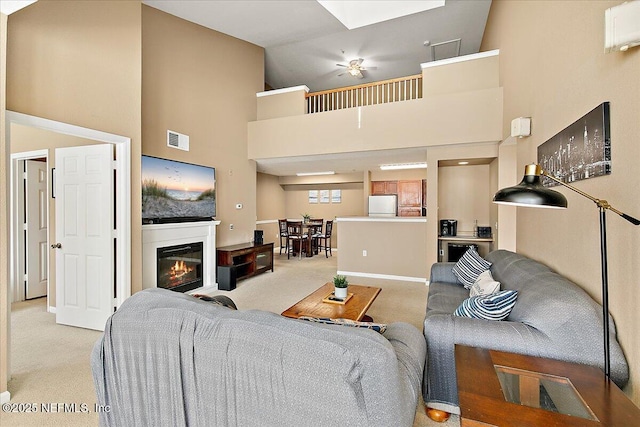 carpeted living room with high vaulted ceiling