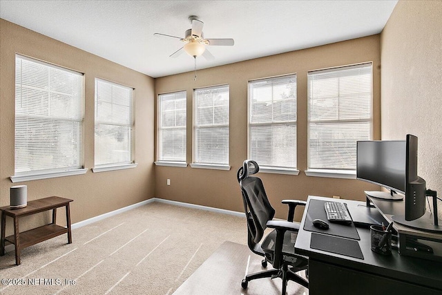 carpeted home office featuring ceiling fan
