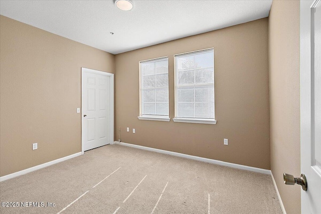 spare room featuring light colored carpet
