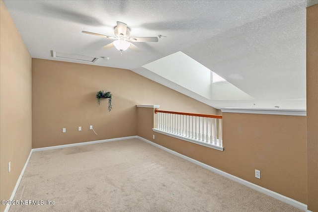 bonus room featuring vaulted ceiling, a textured ceiling, and light colored carpet