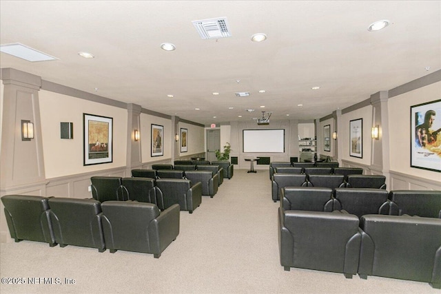 cinema room featuring ornate columns and light colored carpet