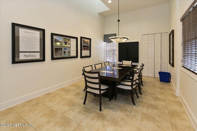 dining area with a high ceiling and light tile patterned floors