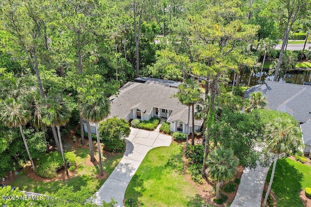 aerial view of property and surrounding area featuring a heavily wooded area