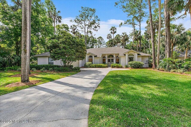 single story home featuring driveway, a front yard, and stucco siding