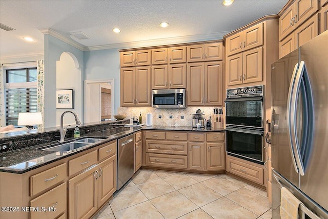 kitchen featuring black appliances, a sink, crown molding, a peninsula, and dark stone counters