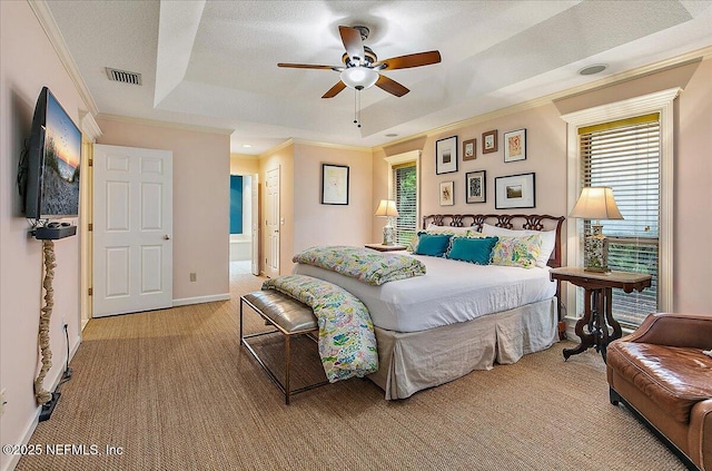 bedroom featuring light colored carpet, a tray ceiling, crown molding, baseboards, and ceiling fan