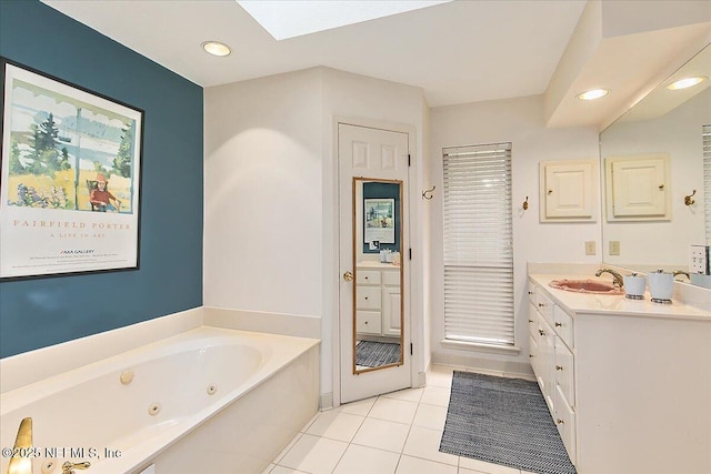 bathroom featuring a skylight, tile patterned floors, vanity, a whirlpool tub, and recessed lighting